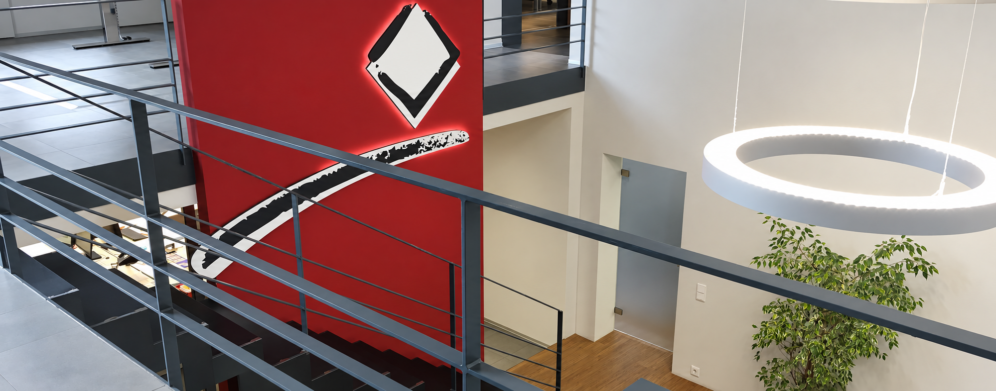 Fertiggestellter Büro-Innenraum mit roter Akzentwand und hinterleuchtetem Logo